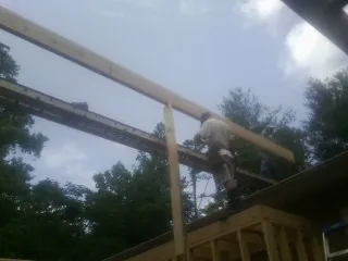Carpenter setting a ridge beam over a new addition frame — Ice Dam Removal by Roofing Brothers in Blacksville