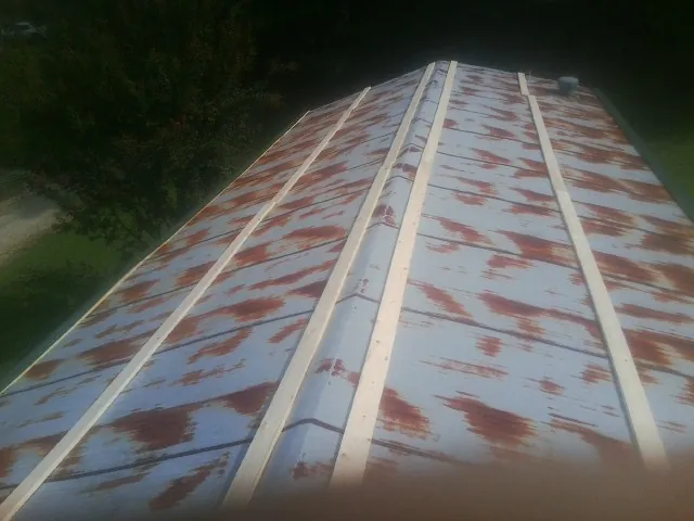 Rusted metal roof panels with new wood purlins before replacement — Storm Damage Roof Repair in Blacksville by Roofing Brothers