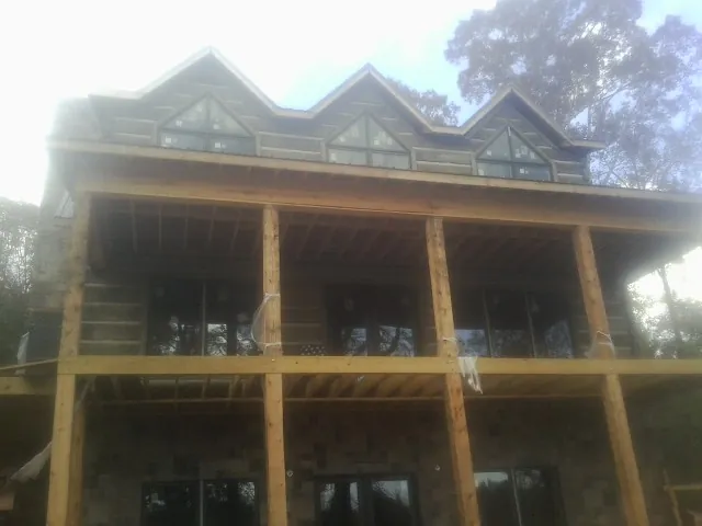 Dormers and porch framing on a large log home under construction — Roof Coating work by our crew in Blacksville