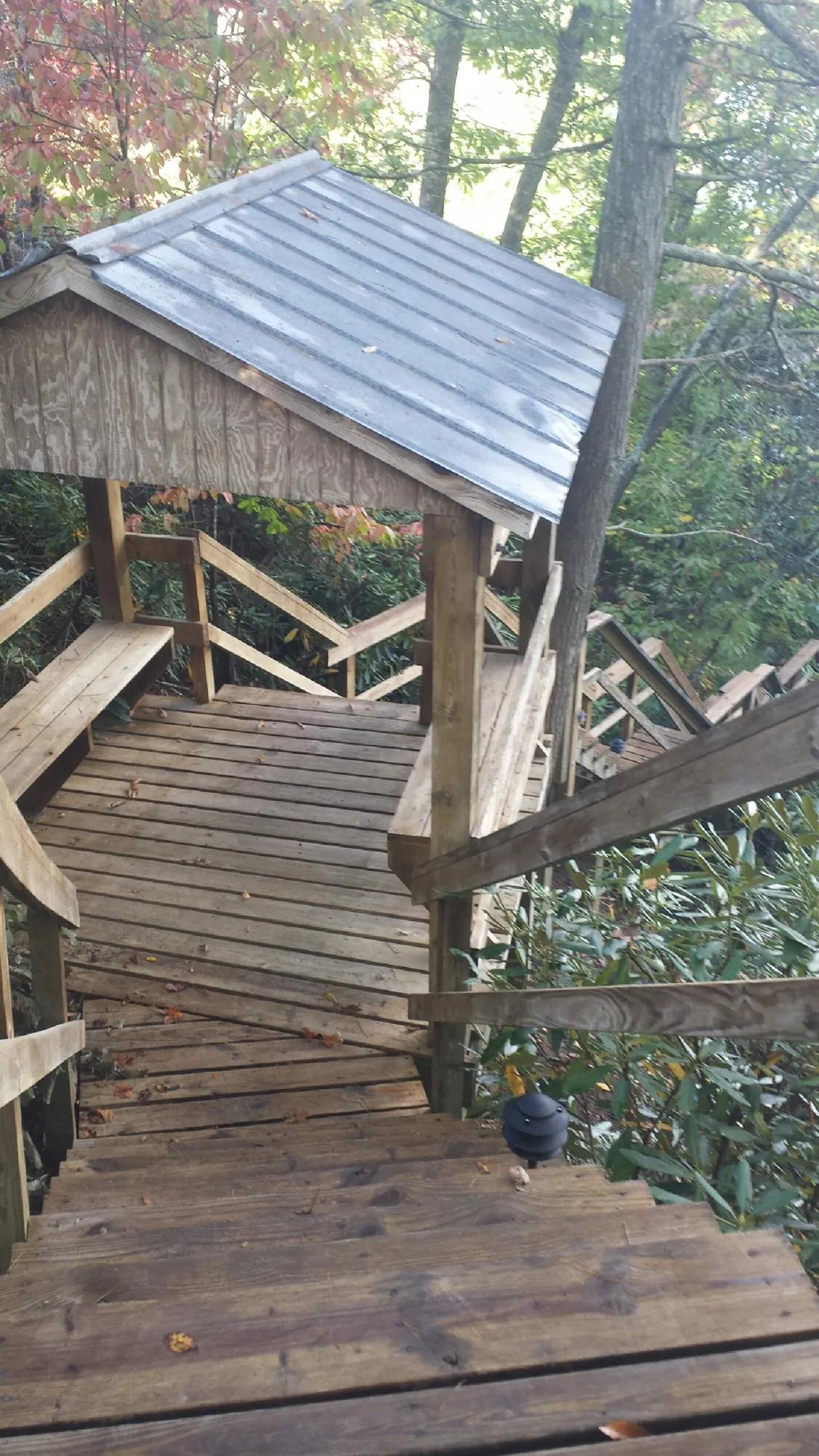 Metal roofed shelter over wooden steps on a wooded walkway — Skylight Repair & Installation work by our crew in Blacksville