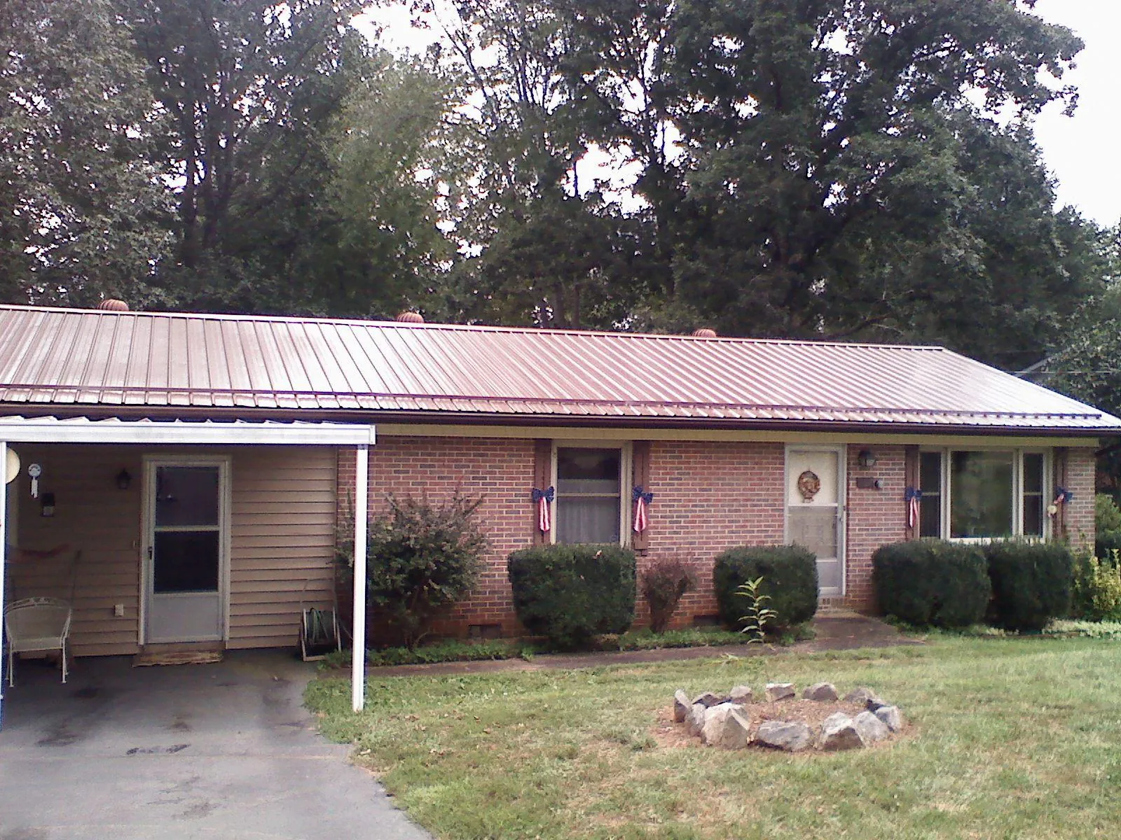 Bronze metal roof and carport on a brick ranch home — Roof Repair work by our crew in Blacksville